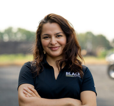 A woman in a black polo shirt with the 