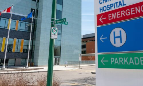A directional signpost in an urban setting with multiple street and hospital signs.