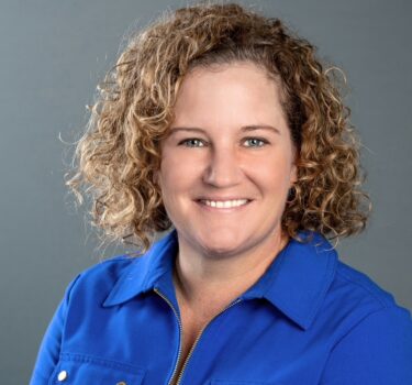 Headshot of women in blue button up